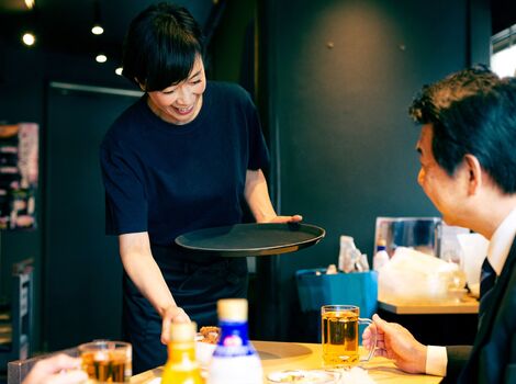 料理を運ぶ女性スタッフ