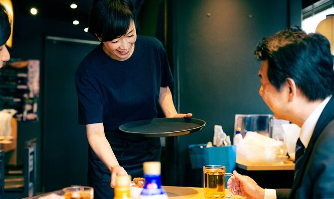 料理を運ぶ女性スタッフ